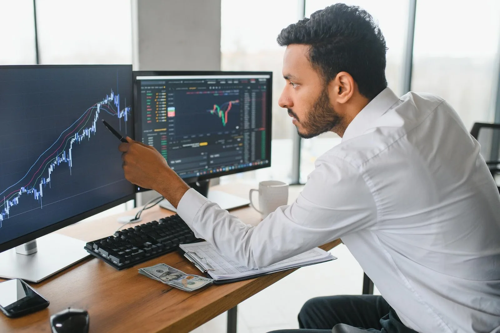 Trader analizando un gráfico técnico en pantalla con indicadores de tendencia